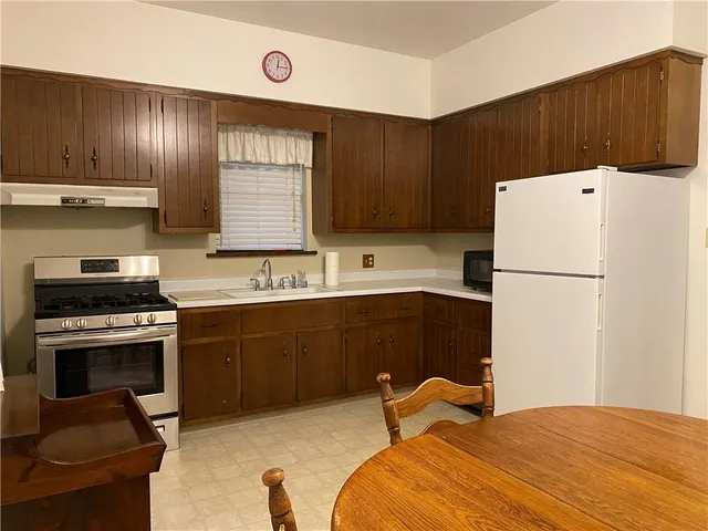a kitchen with a refrigerator and a stove top oven