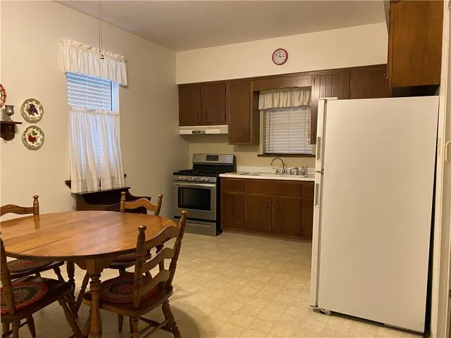 a kitchen with a refrigerator a stove a sink and a dining table