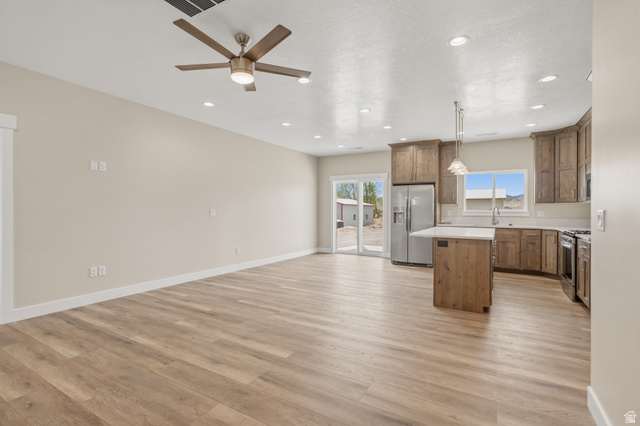 157 West 100 South Joseph, UT 84739 - Photo 30 of 30 Kitchen featuring a kitchen island, light countertops, open floor plan, stainless steel appliances, and a ceiling fan