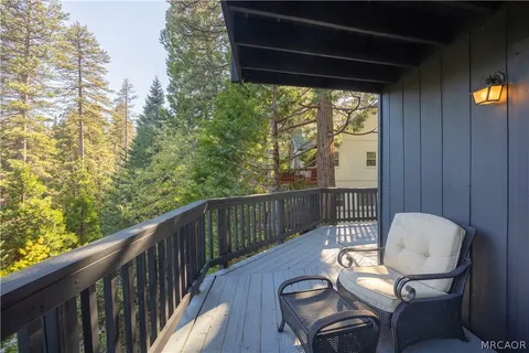 a balcony with wooden floor in front of house