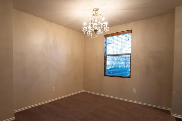 en empty room with windows and chandelier
