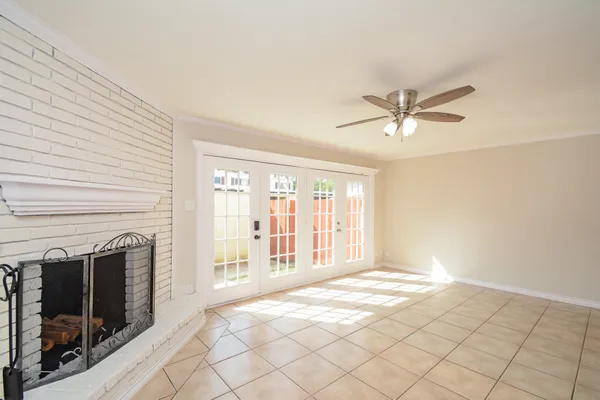 a view of an empty room with window and a fireplace