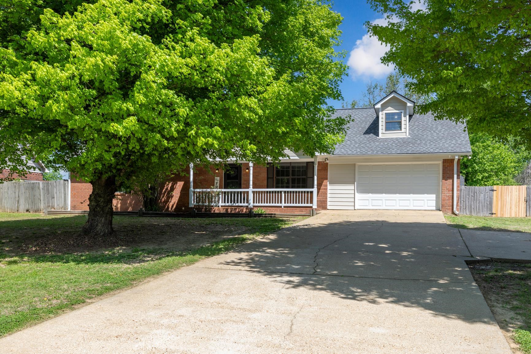 284 Pwr Loop Munford, TN 38058 - Photo 1 of 36 View of front of house with a shingled roof, brick siding, covered porch, driveway, and a garage