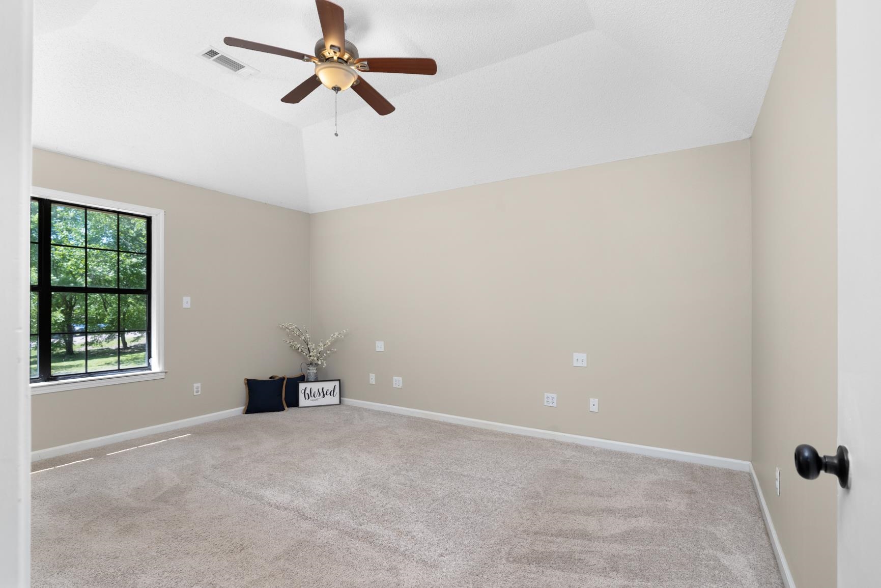284 Pwr Loop Munford, TN 38058 - Photo 14 of 36 Unfurnished room featuring light carpet, ceiling fan, and lofted ceiling