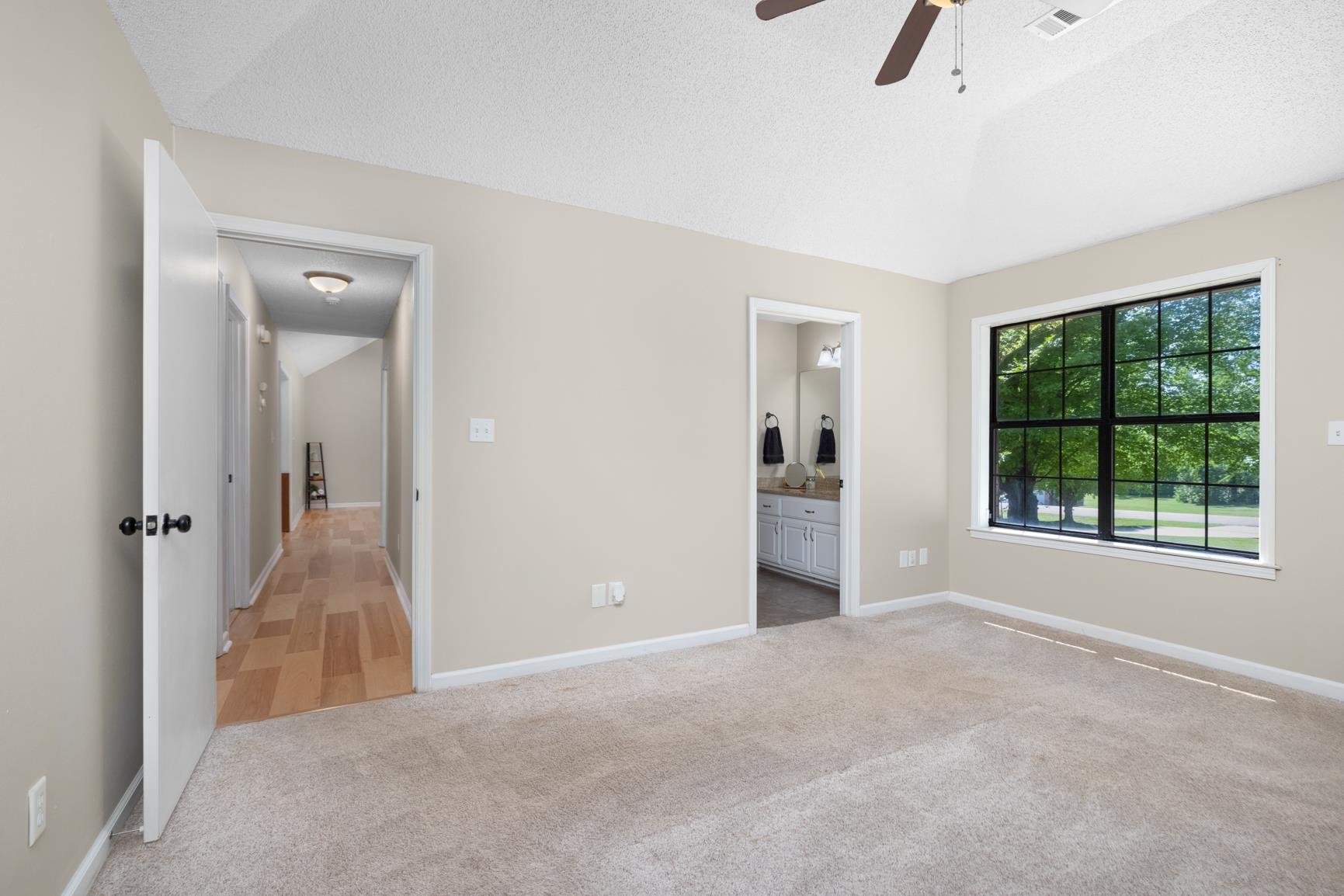 284 Pwr Loop Munford, TN 38058 - Photo 16 of 36 Unfurnished bedroom with light carpet, connected bathroom, and ceiling fan