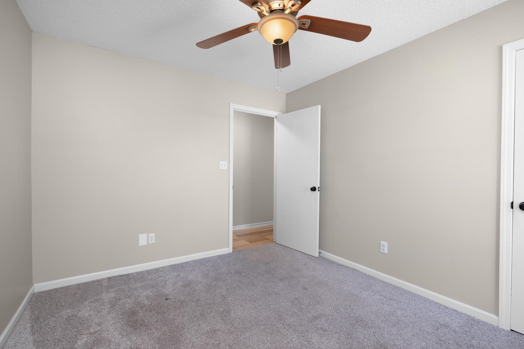 284 Pwr Loop Munford, TN 38058 - Photo 22 of 36 Unfurnished bedroom with a textured ceiling, a ceiling fan, and light carpet