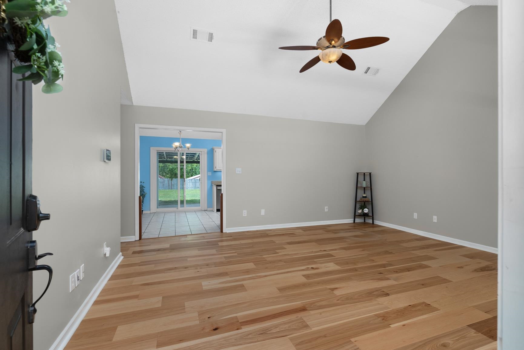 284 Pwr Loop Munford, TN 38058 - Photo 3 of 36 Unfurnished living room with light wood-style floors, lofted ceiling, a ceiling fan, and hanging lights