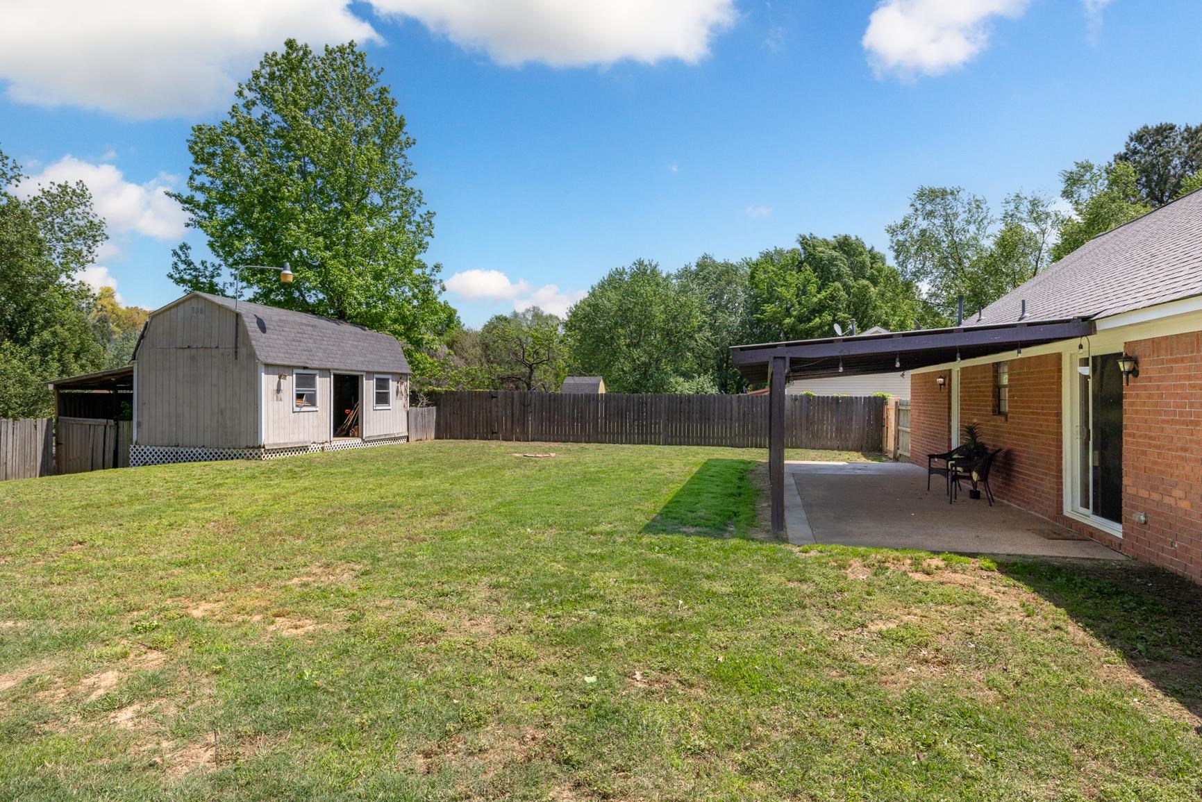 284 Pwr Loop Munford, TN 38058 - Photo 33 of 36 Fenced backyard featuring an outdoor structure and a patio area