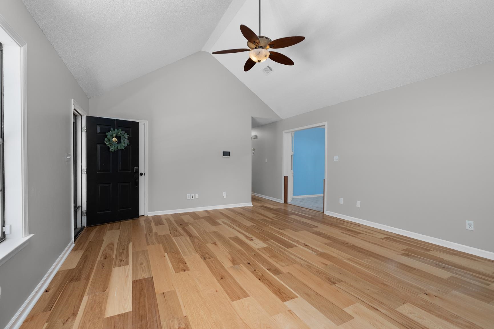 284 Pwr Loop Munford, TN 38058 - Photo 6 of 36 Unfurnished living room with light wood-style floors, ceiling fan, and a high ceiling