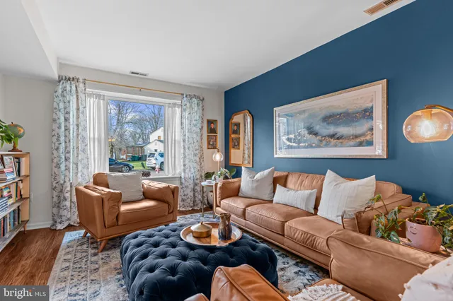 a living room with furniture and a window with wooden floor