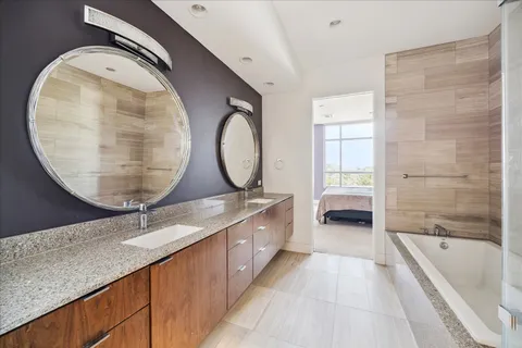 a spacious bathroom with a tub sink and mirror