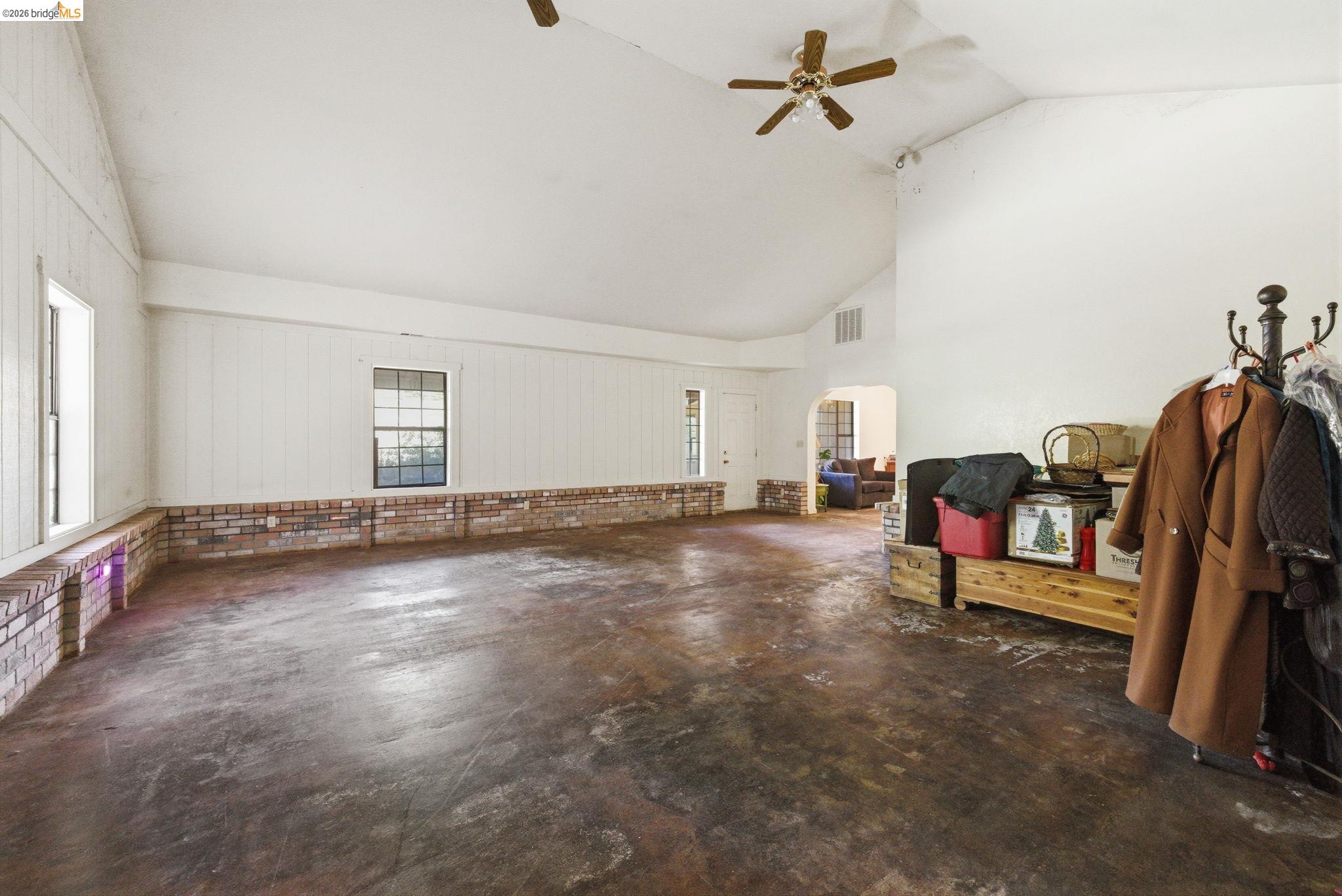 23608 Porcina Way Columbia, CA 95310 - Photo 24 of 51 Living area with concrete floors, lofted ceiling, ceiling fan, and arched walkways