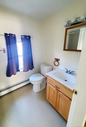 a bathroom with a toilet sink and mirror