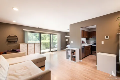 a living room with furniture a large window and a sink