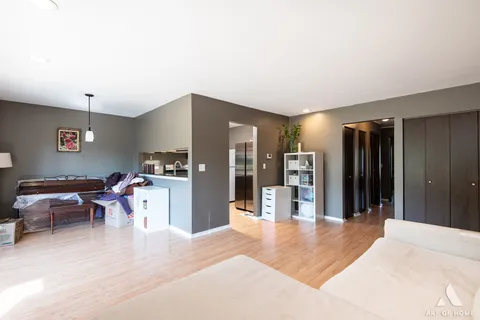 a living room with furniture a refrigerator and kitchen view