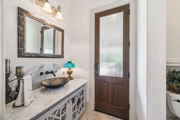 a bathroom with a granite countertop sink a mirror and vanity