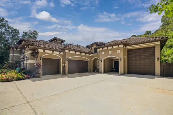 a view of a house with a yard and potted plants