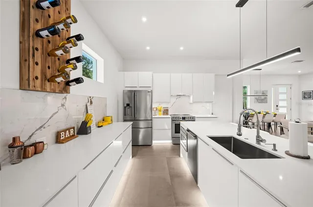 a kitchen with stainless steel appliances a sink a stove a refrigerator and cabinets