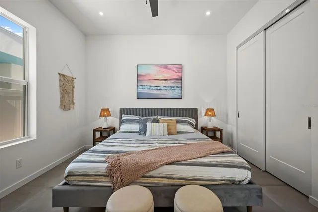 a bedroom with bed and a painting on the wall