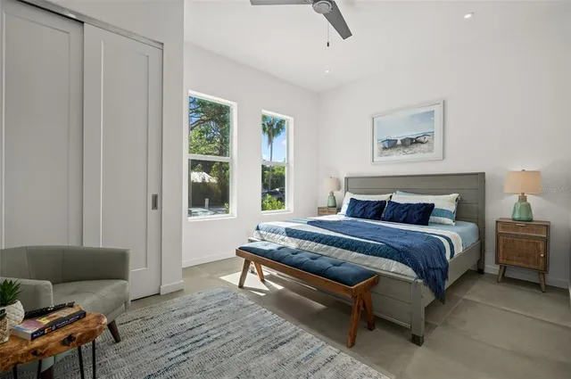 a spacious bedroom with a bed and wooden floor