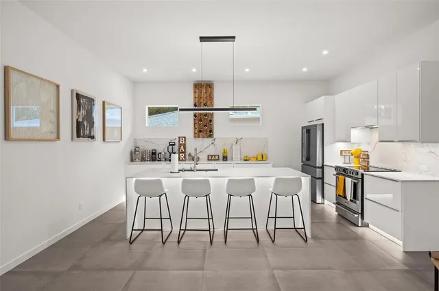 a kitchen with a sink dining table and chairs
