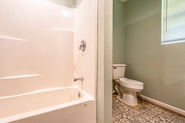 a bathroom with a toilet and a bathtub