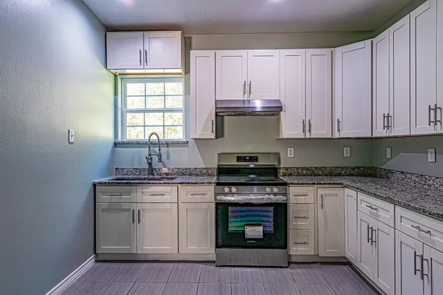 a kitchen with stainless steel appliances granite countertop a stove sink and cabinets