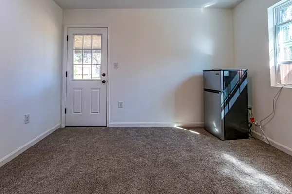 an empty room with a window and ceiling fan