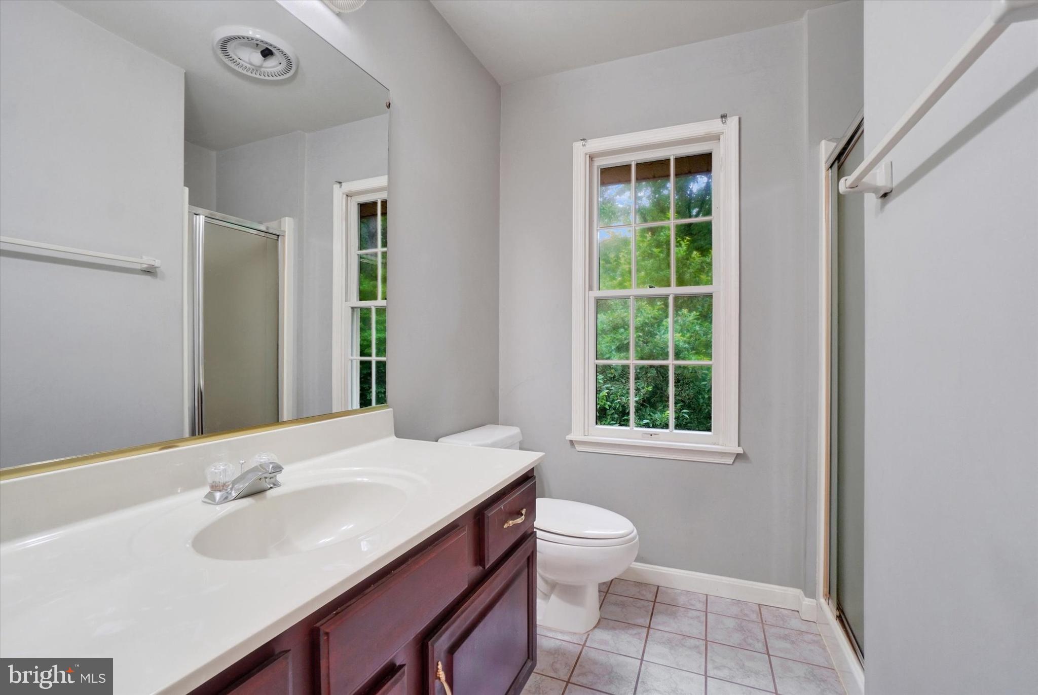 5677 Woods Road Stewartstown, PA 17363 - Photo 18 of 26 a bathroom with a sink a toilet and a window