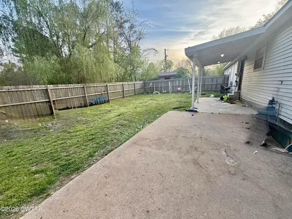 a view of a yard with wooden fence
