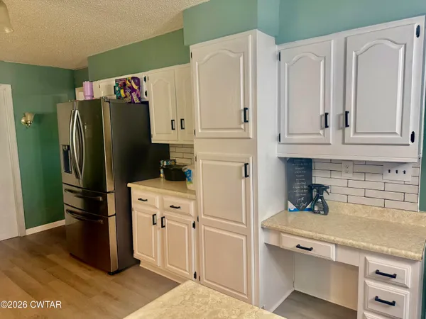 a kitchen with stainless steel appliances white cabinets and a refrigerator