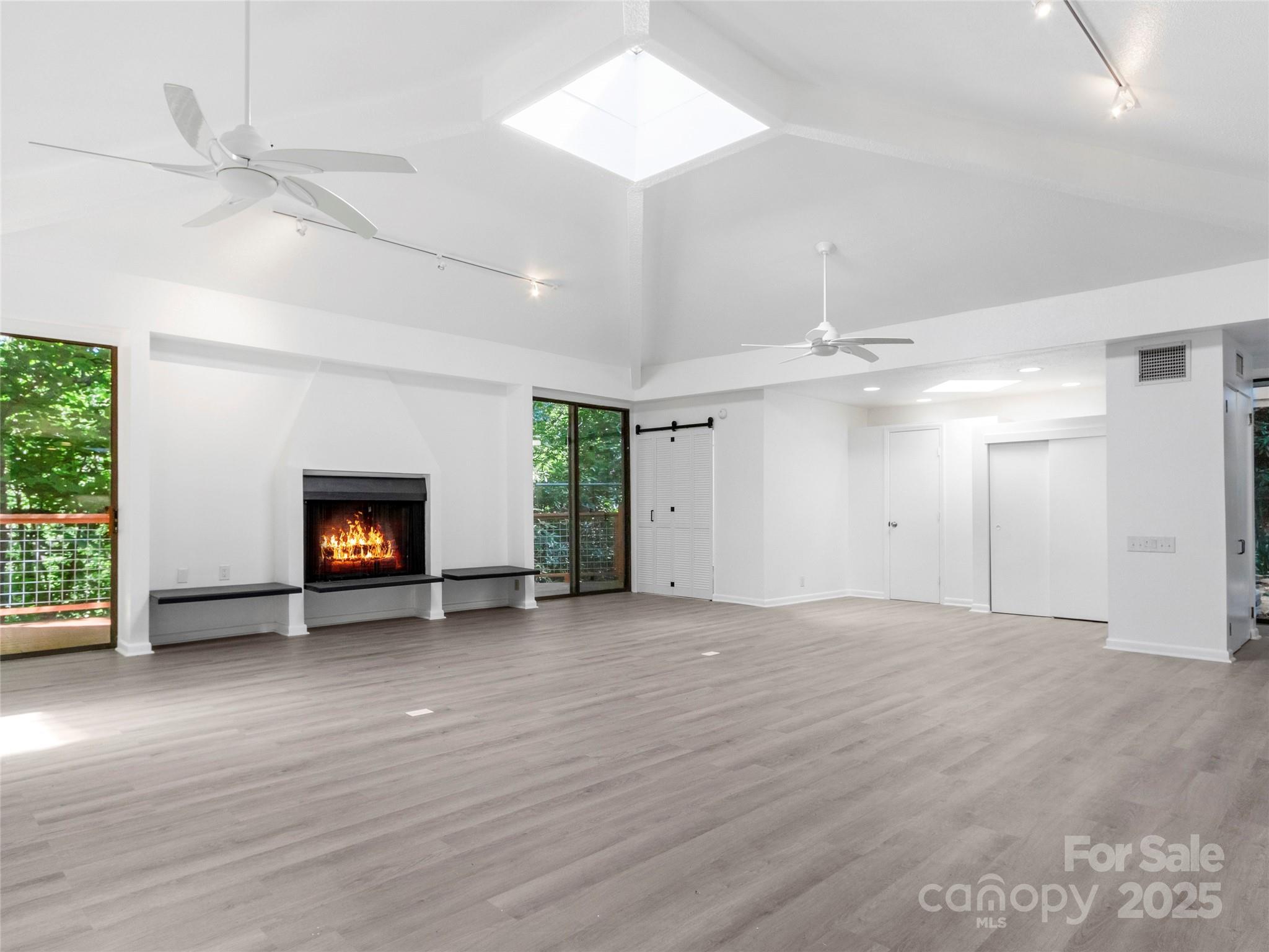 141 Wildflower Road Spruce Pine, NC 28777 - Photo 16 of 22 an empty room with wooden floor fireplace and windows