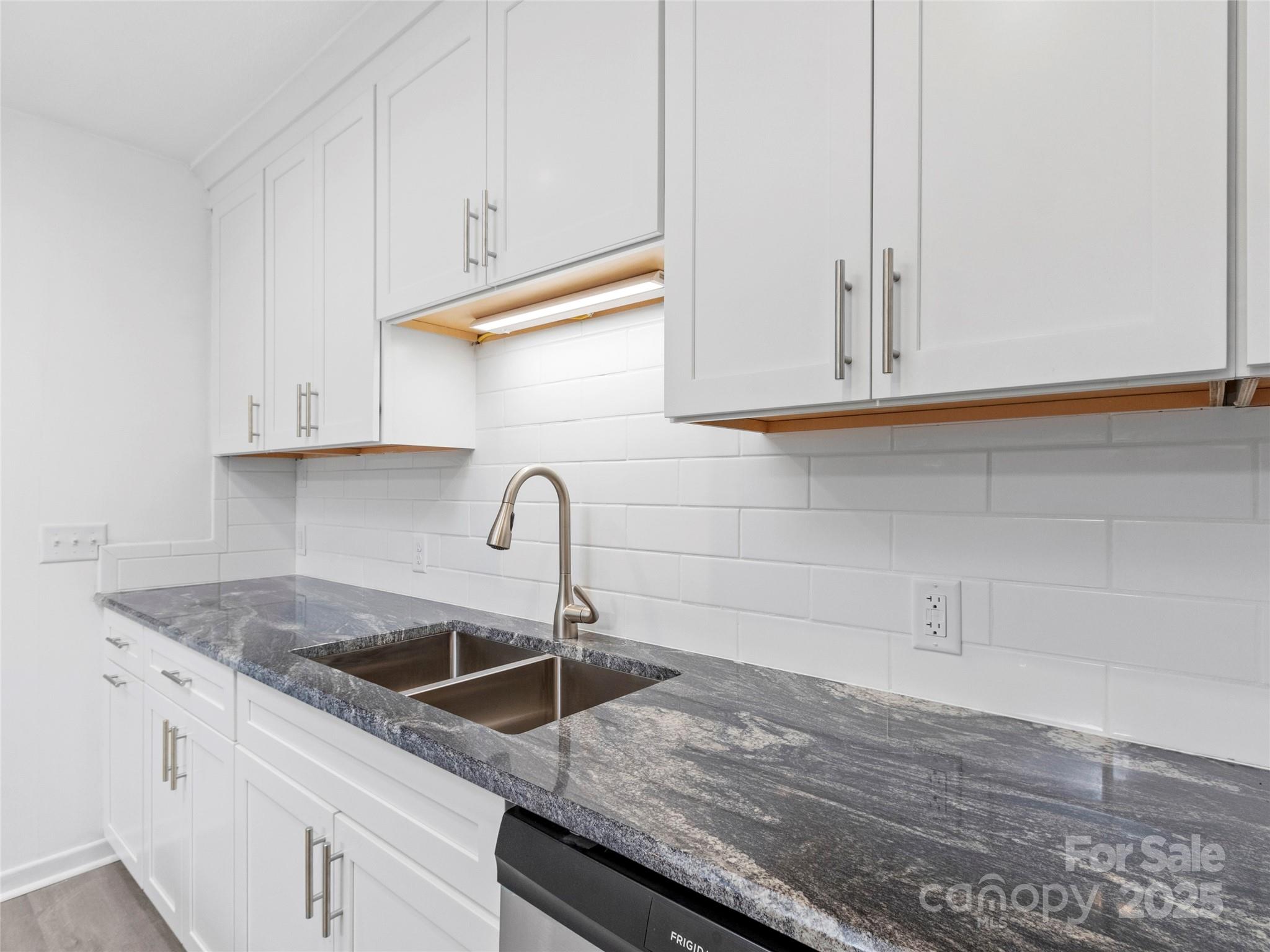 141 Wildflower Road Spruce Pine, NC 28777 - Photo 21 of 22 a kitchen with granite countertop white cabinets and a sink