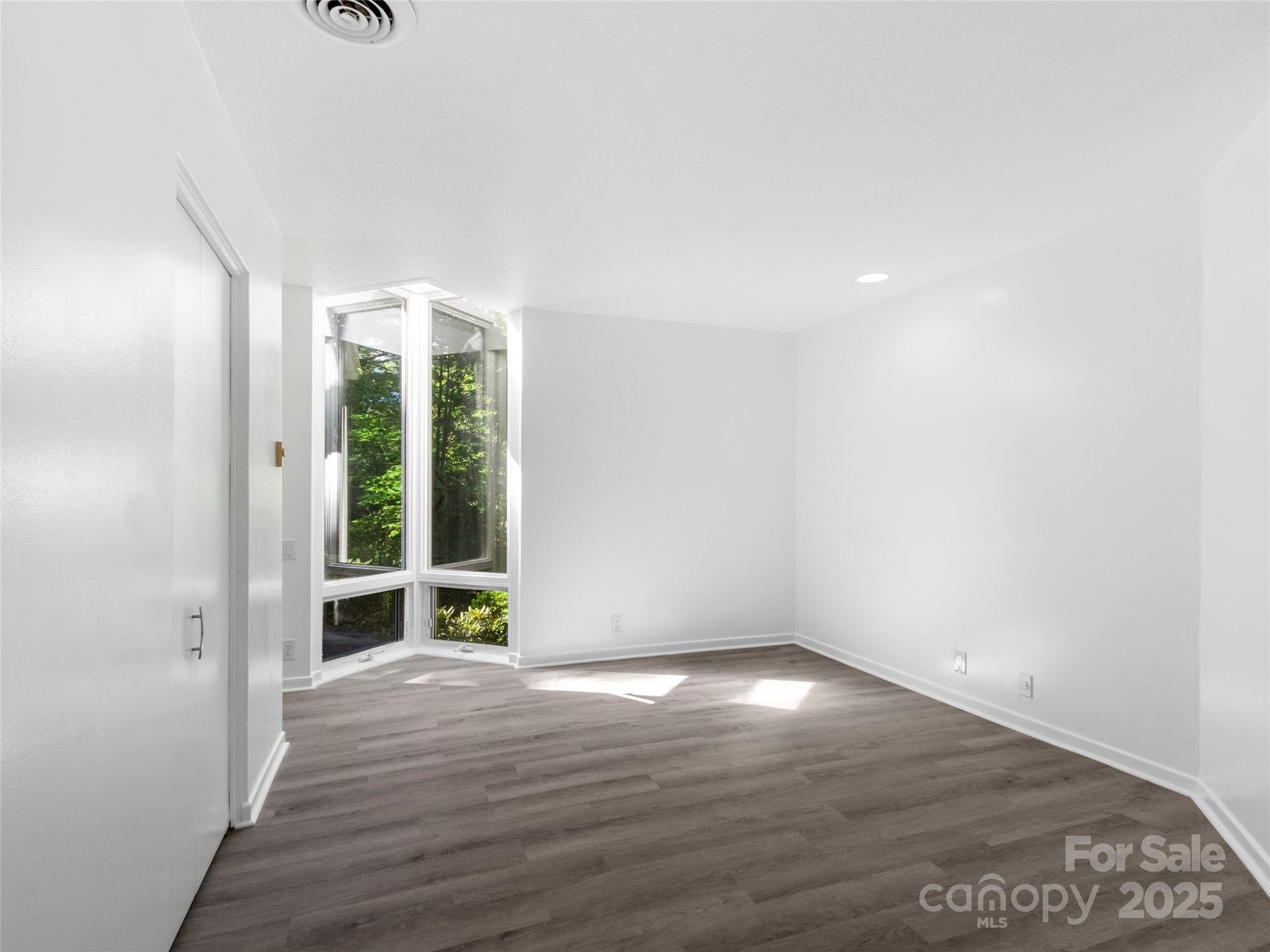 141 Wildflower Road Spruce Pine, NC 28777 - Photo 22 of 22 an empty room with wooden floor and windows
