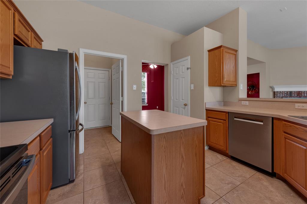 910 Derby Court Celina, TX 75009 - Photo 11 of 27 a kitchen with stainless steel appliances granite countertop a sink and a refrigerator