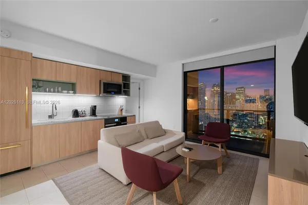 a kitchen with stainless steel appliances kitchen island granite countertop a refrigerator a stove a sink dishwasher with a dining table and chairs with wooden floor