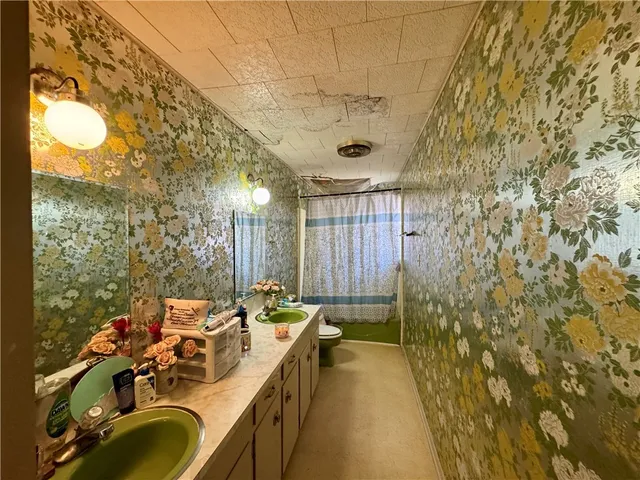 a bathroom with a sink mirror and shower