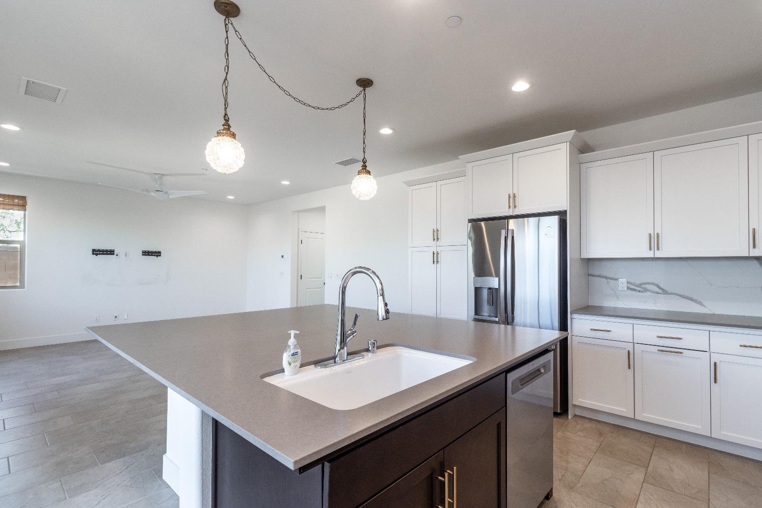 4344 Oak Knoll Road Madera, CA 93636 - Photo 12 of 33 a kitchen with kitchen island a sink a counter space appliances and cabinets