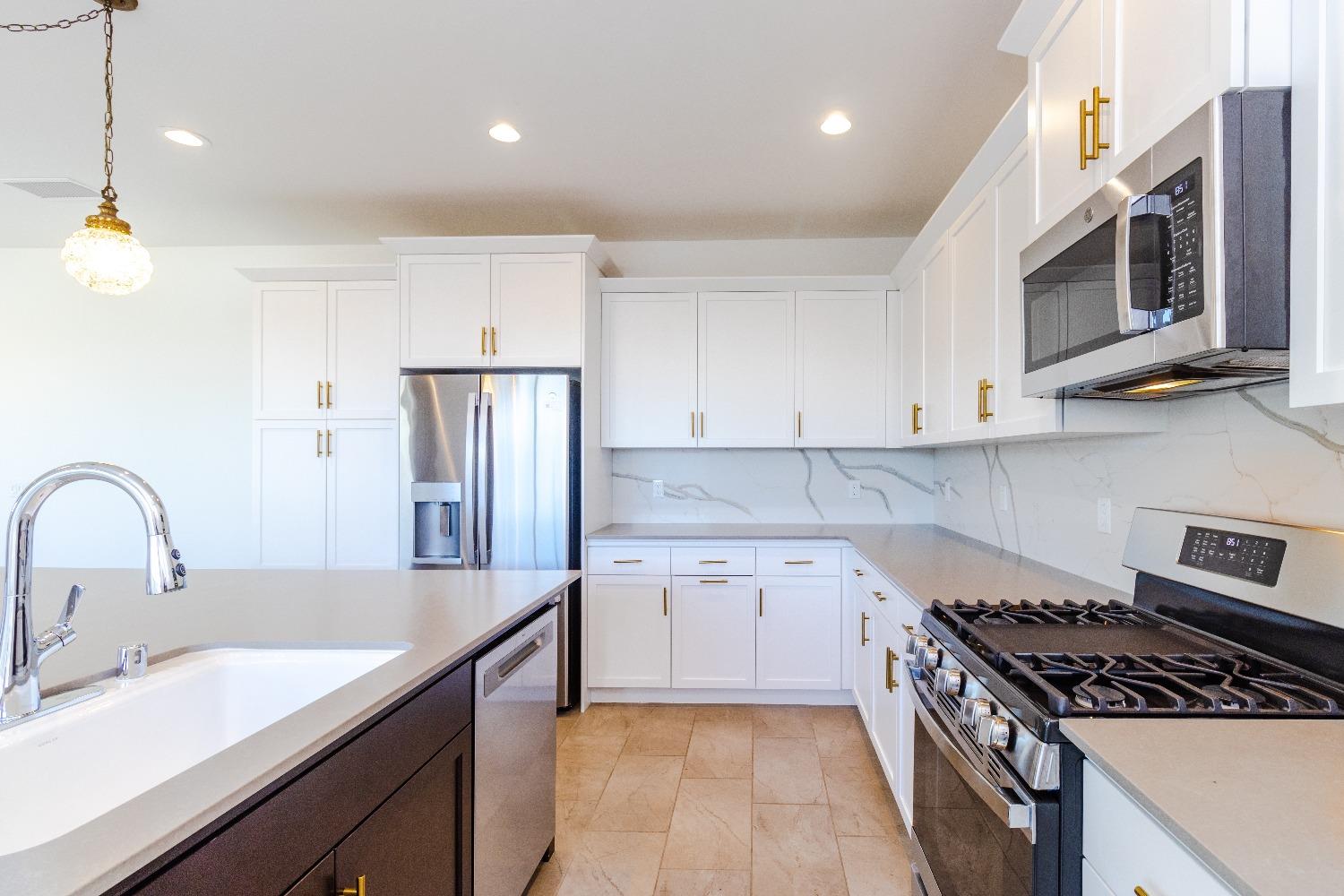 4344 Oak Knoll Road Madera, CA 93636 - Photo 13 of 33 a kitchen with stainless steel appliances granite countertop a sink stove and refrigerator