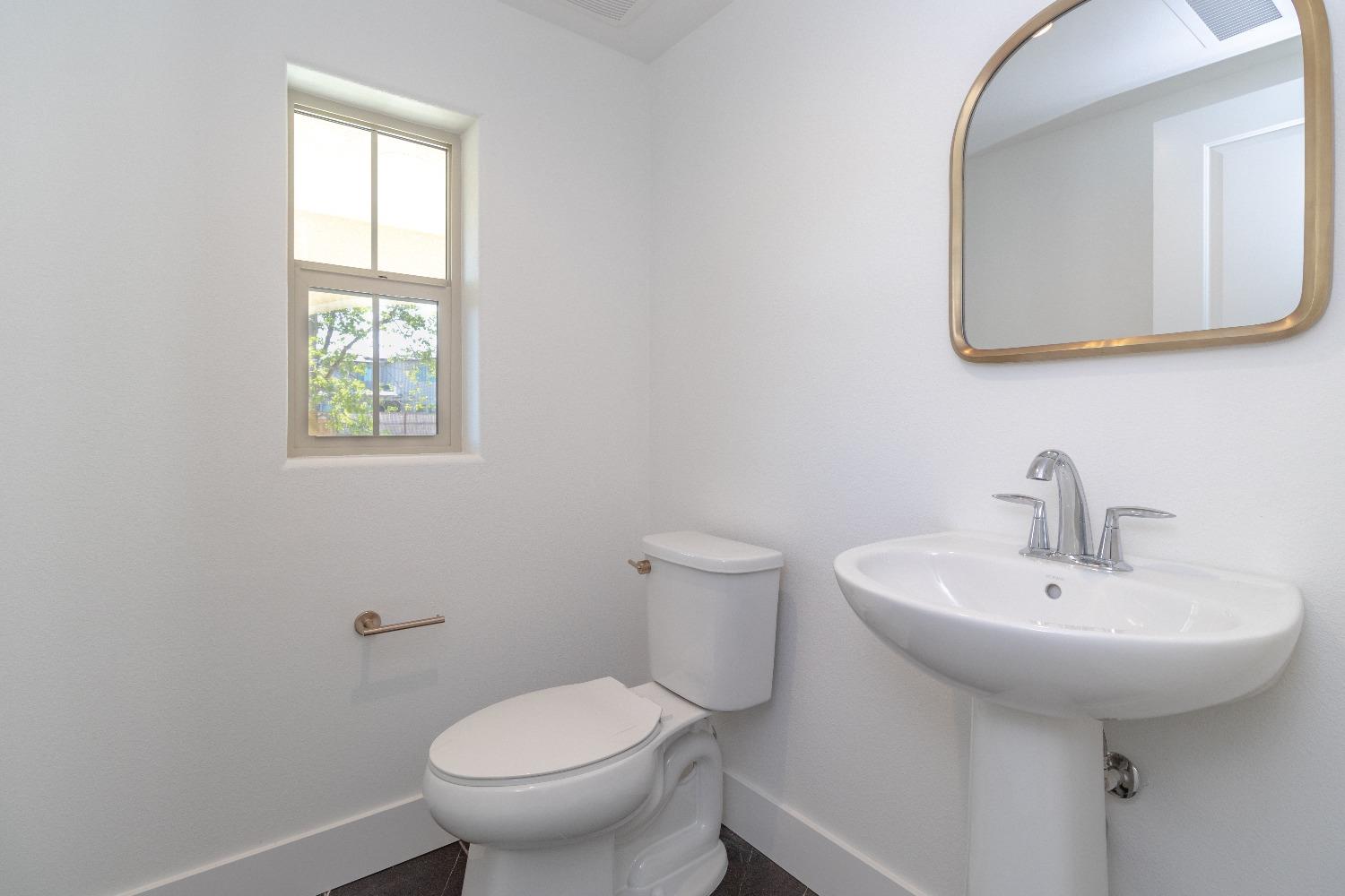 4344 Oak Knoll Road Madera, CA 93636 - Photo 14 of 33 a bathroom with a toilet sink and mirror