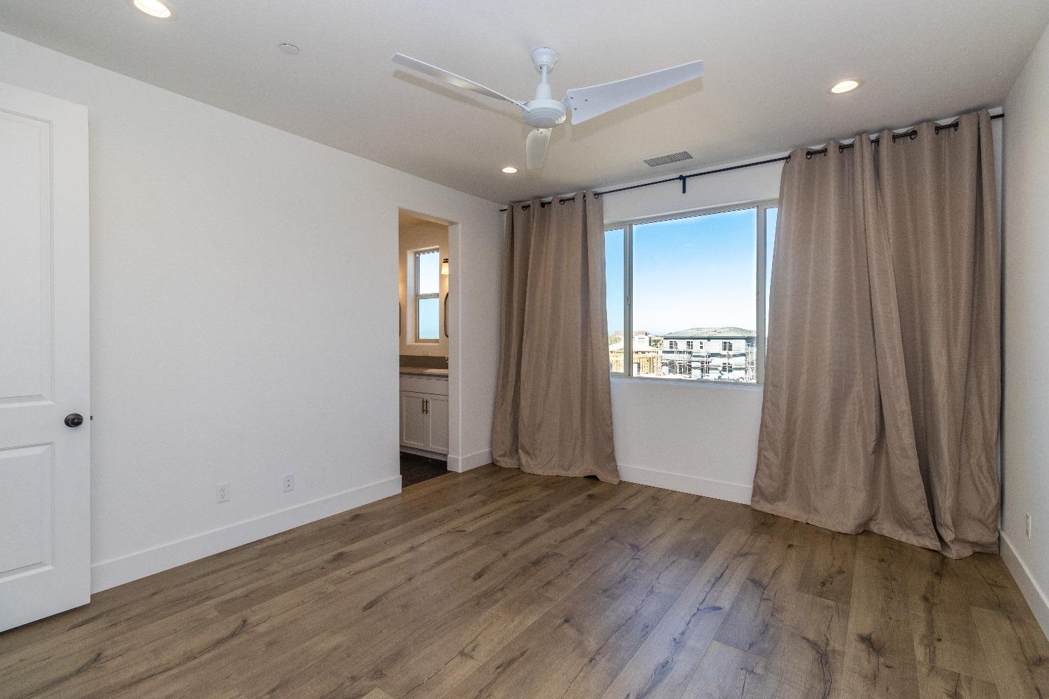 4344 Oak Knoll Road Madera, CA 93636 - Photo 15 of 33 an empty room with wooden floor and windows