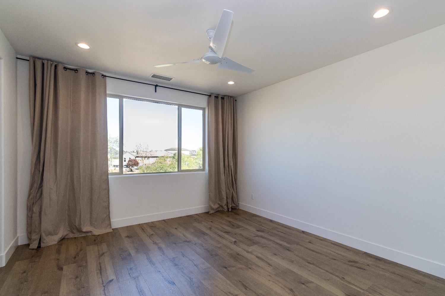4344 Oak Knoll Road Madera, CA 93636 - Photo 16 of 33 an empty room with wooden floor and windows