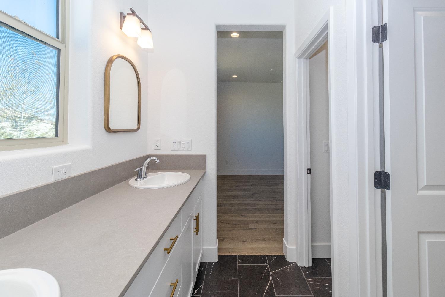 4344 Oak Knoll Road Madera, CA 93636 - Photo 19 of 33 a bathroom with a granite countertop sink and a mirror