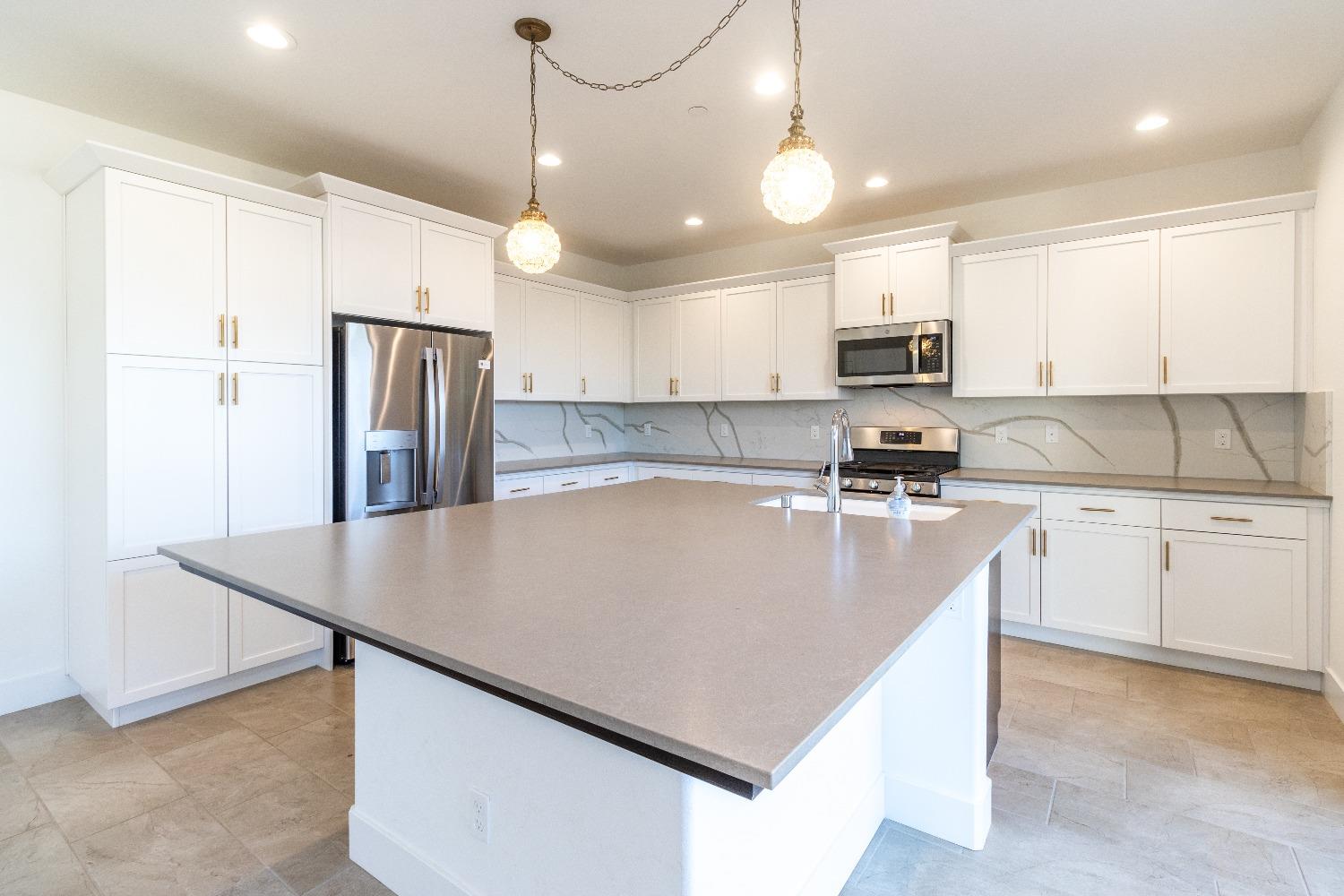4344 Oak Knoll Road Madera, CA 93636 - Photo 9 of 33 a large kitchen with stainless steel appliances granite countertop a sink a stove a refrigerator and island