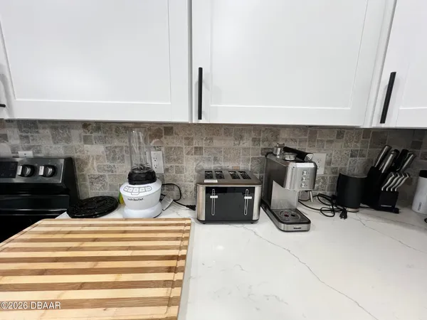 a kitchen with stainless steel appliances a stove a refrigerator a sink dishwasher a oven with a dining table and chairs