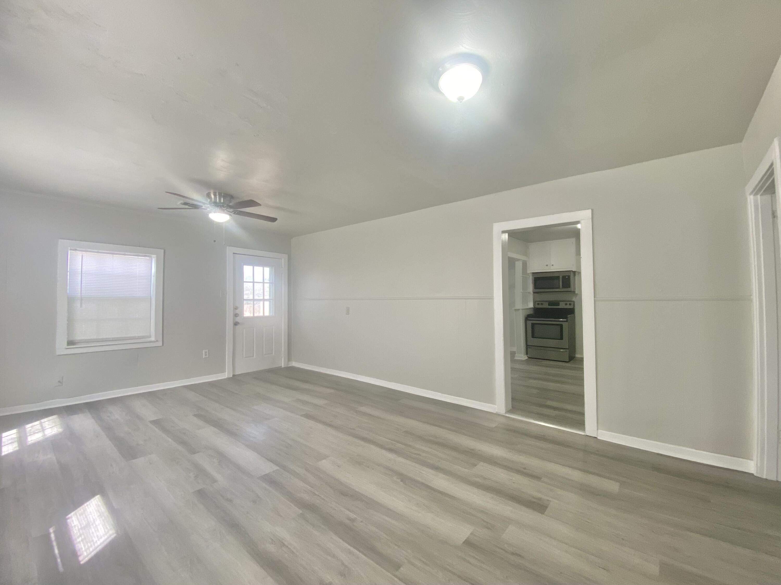 5701 45th Street Lubbock, TX 79414 - Photo 4 of 12 wooden floor in an empty room with a window