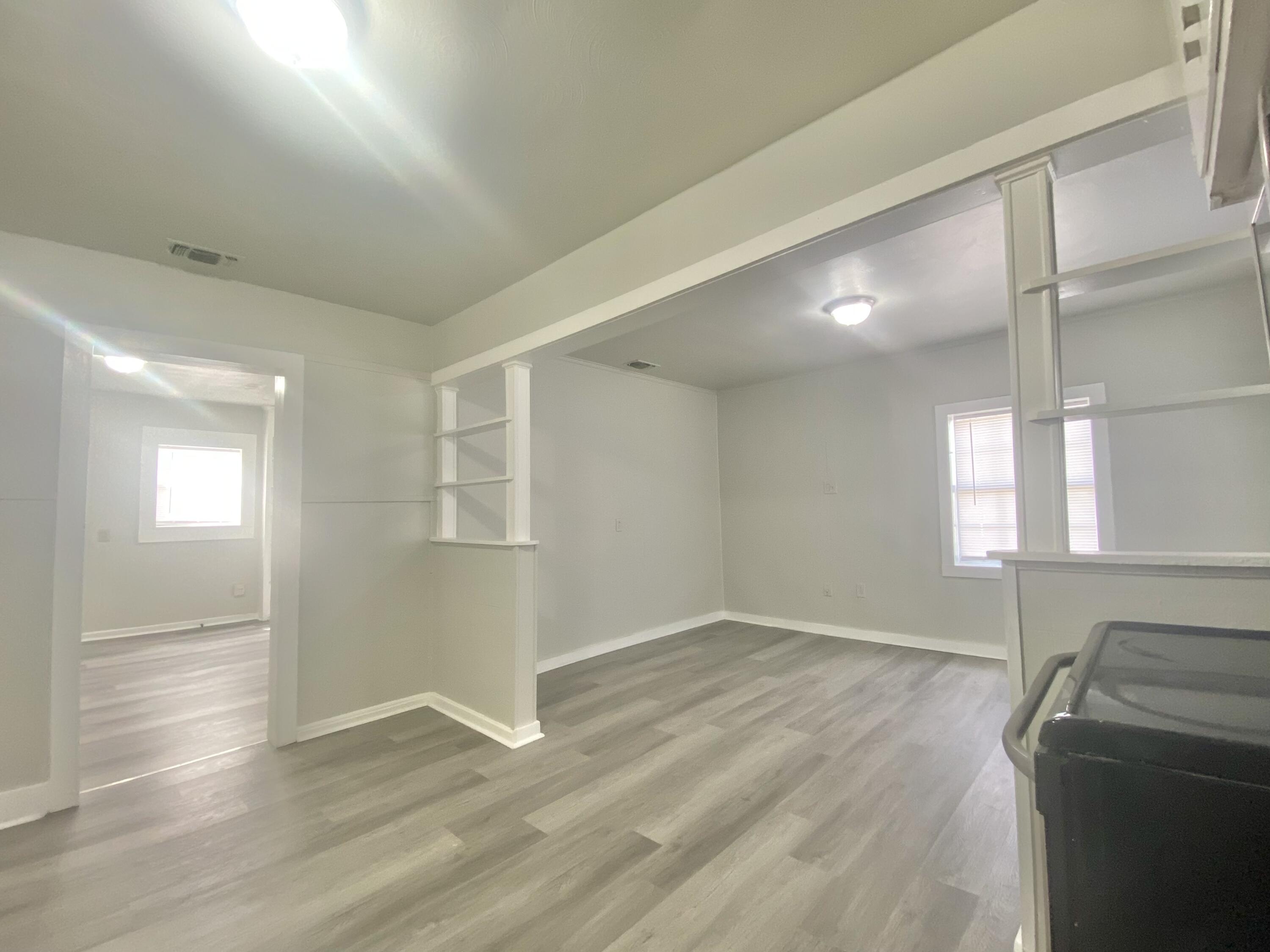 5701 45th Street Lubbock, TX 79414 - Photo 7 of 12 a view of an empty room with wooden floor and a window