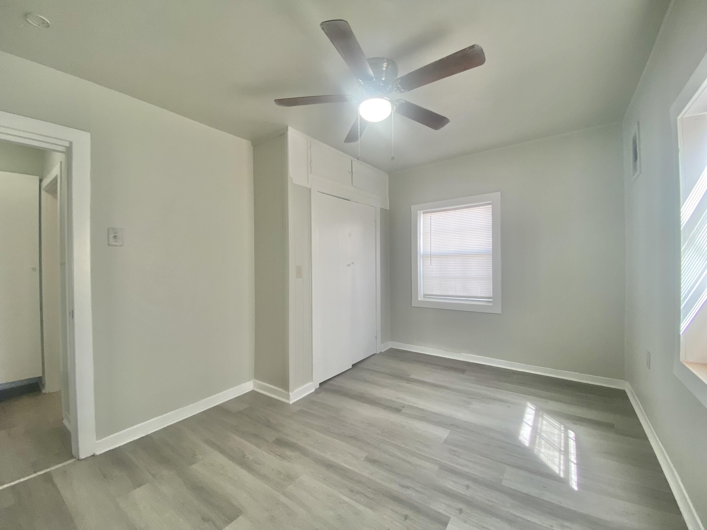 5701 45th Street Lubbock, TX 79414 - Photo 10 of 12 a view of an empty room with wooden floor and a window