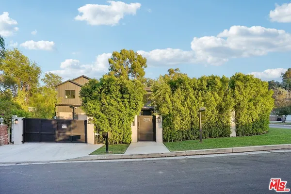 a view of a house with wooden fence