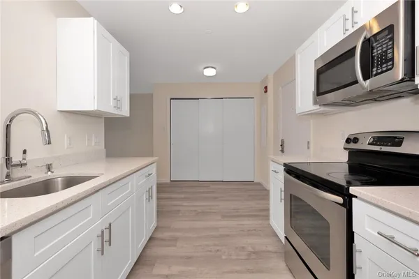 a kitchen with stainless steel appliances granite countertop a sink stove and microwave